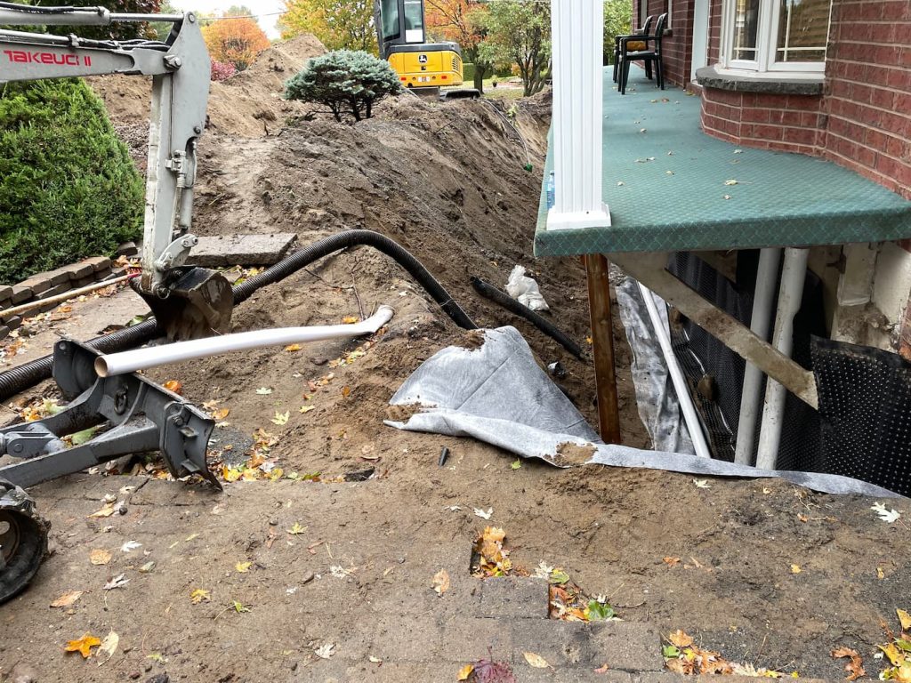 Réparation de drains de fondation avec excavation, drain français et membrane géotextile pour protéger la maison contre l’humidité.